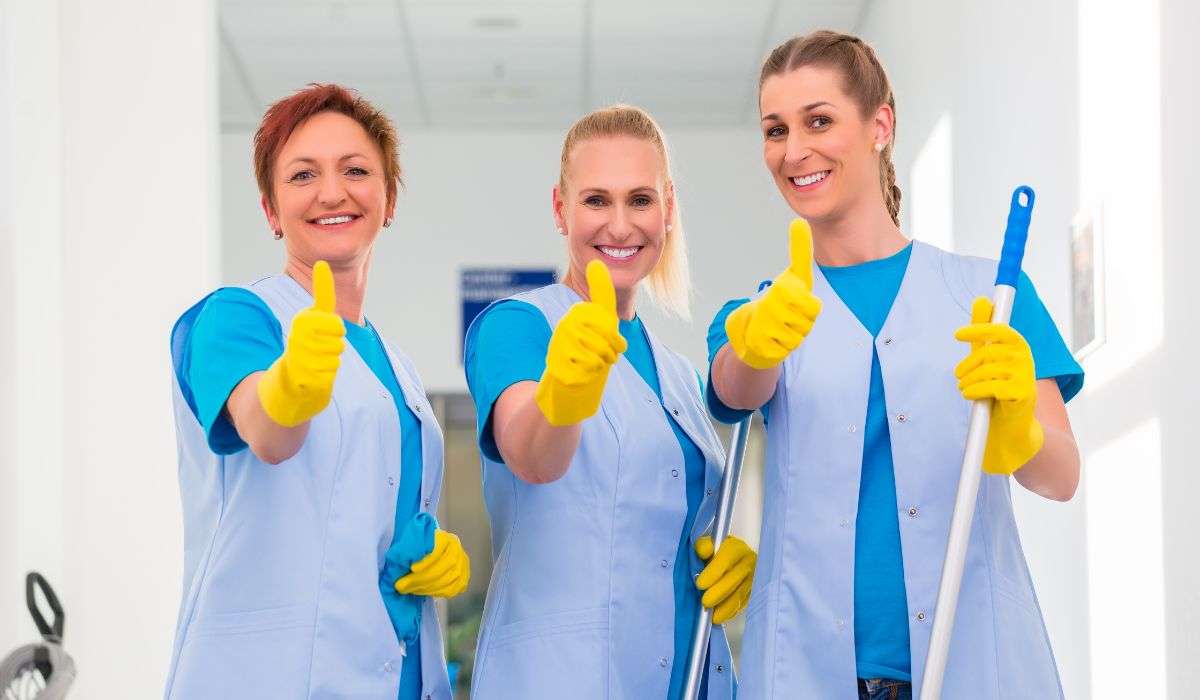 Three cleaning ladies in blue uniforms giving thumbs up, ready for professional maid services in Limassol.